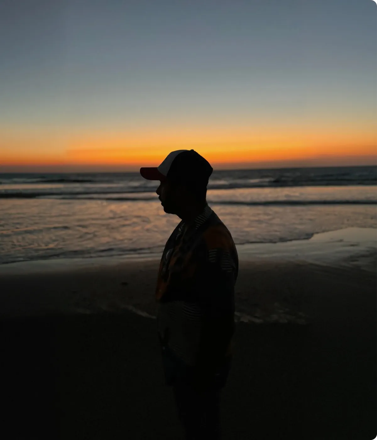 Sohan walking along a beach at sunset
