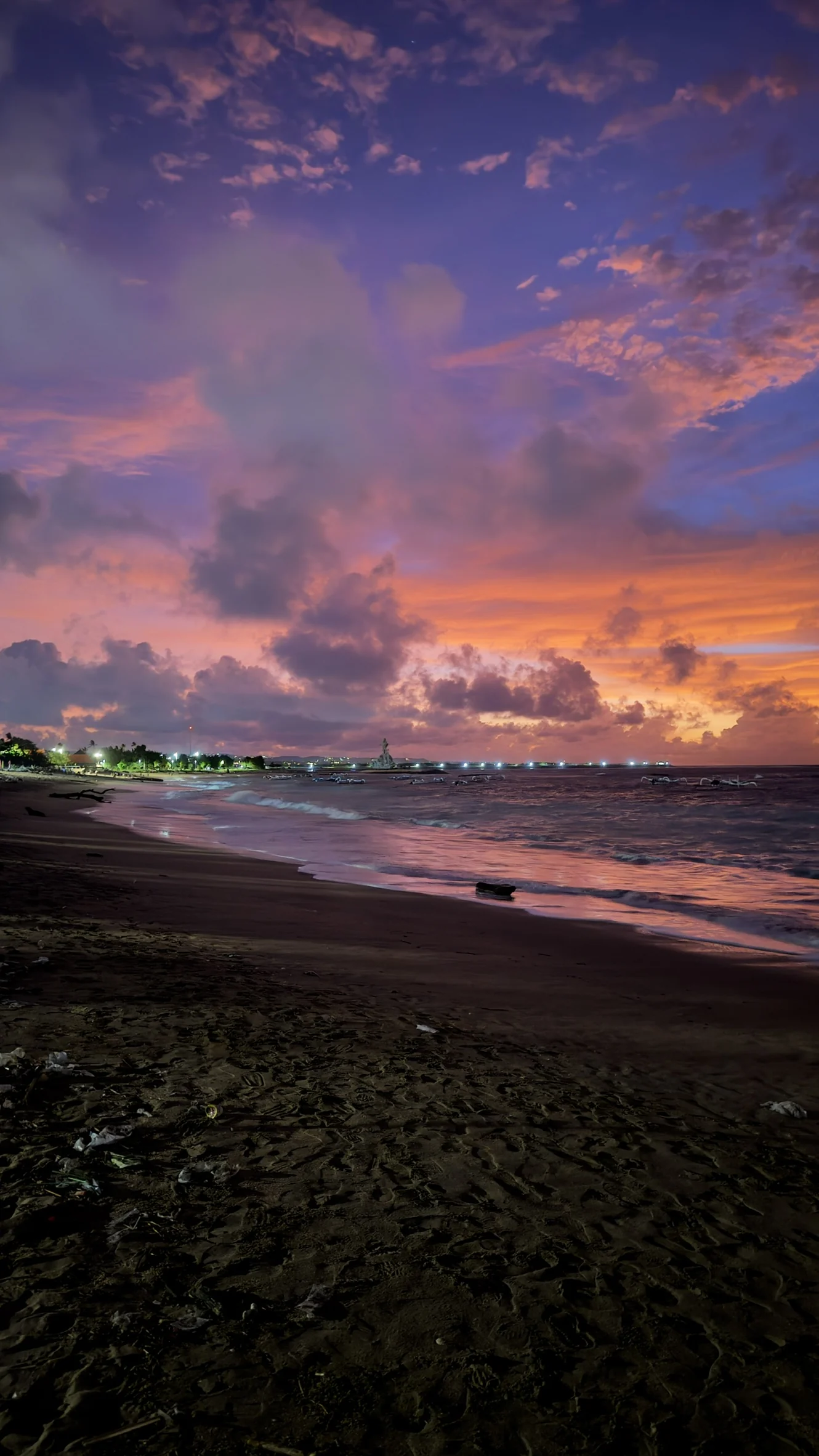 Violet and orange dusk sky over a dark beach