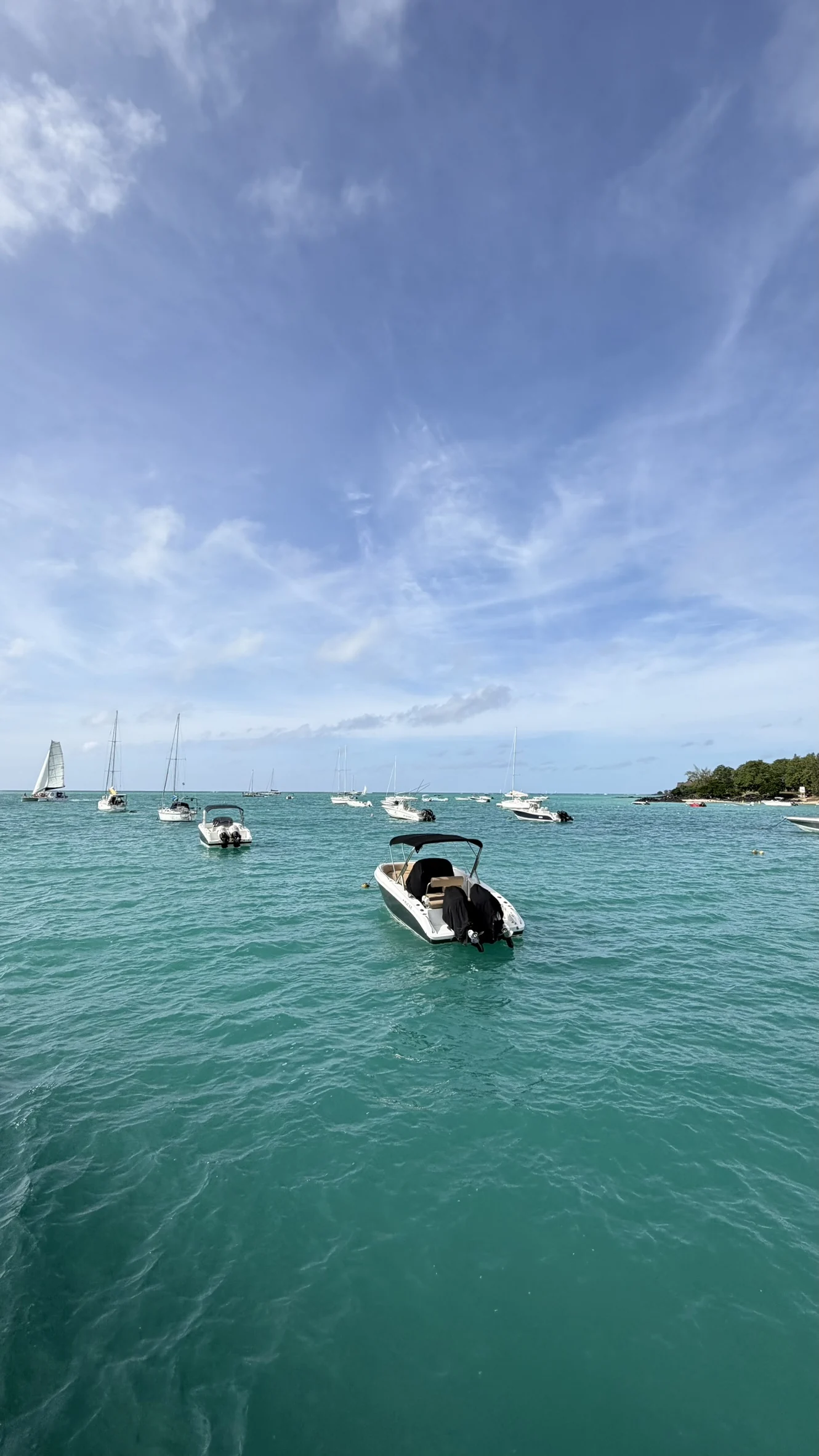 Speedboats moored on turquoise water under a wide sky
