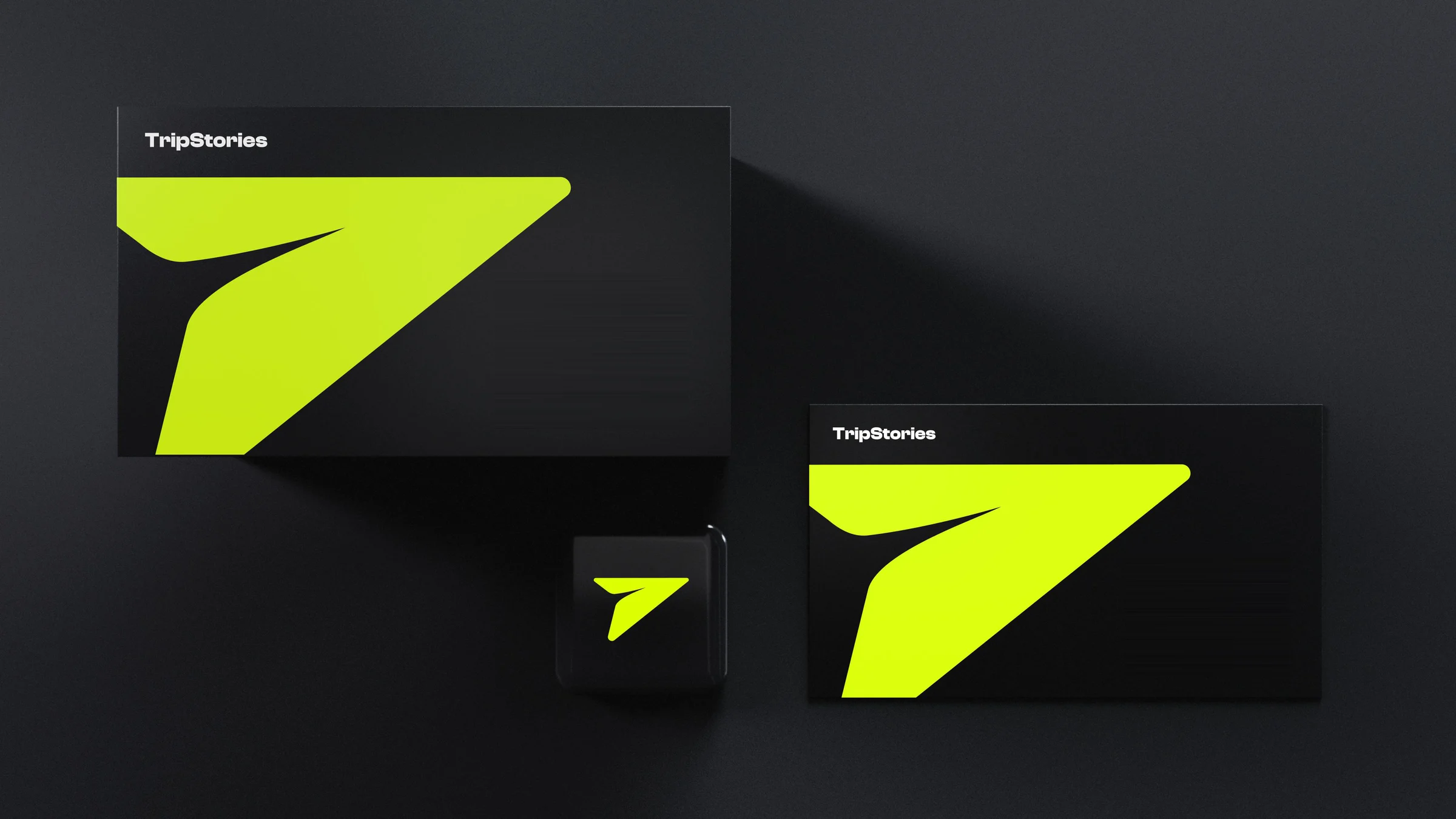 TripStories business cards in the black theme: a lime mark on black with the app icon beside them